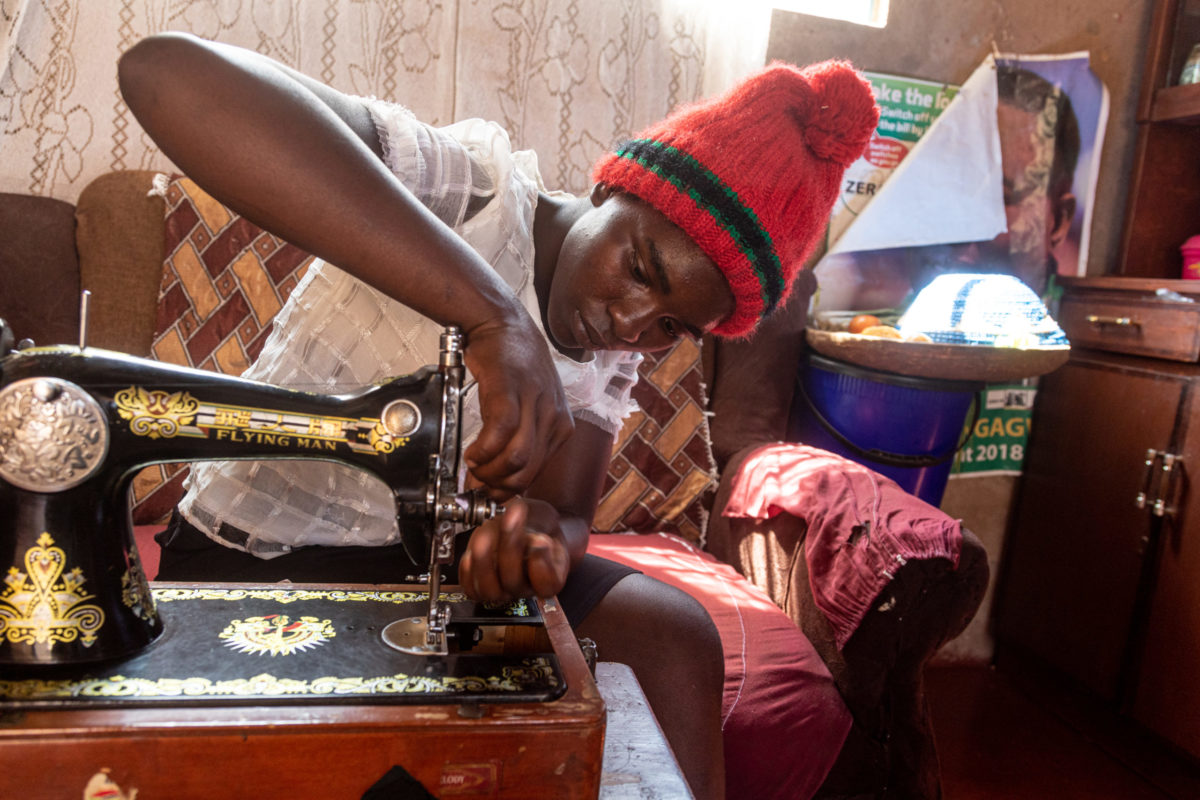 SEPTEMBER 13, 2021: EVERJOY MASASE (19) thread’s a sewing machine, a skill she learnt under her mother-in-law’s guidance. © Charmaine Chitate/ CARE.