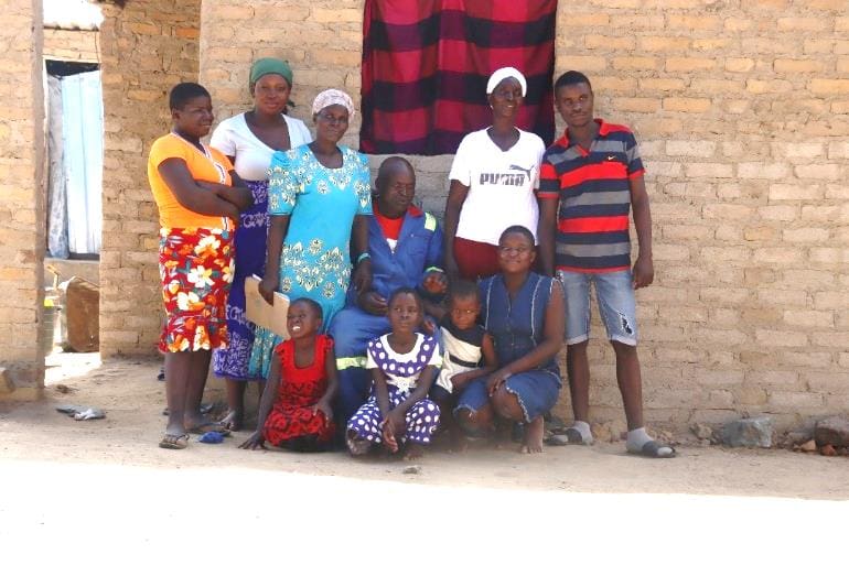 APRIL, 6, 2022: PHILOMINA RONGEDZAI (46) poses for a group photograph with members of her family. ©Sydney Saungweme/ CARE