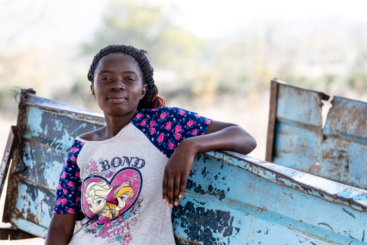 SEPTEMBER 14, 2021: MOREBLESSING TAMAYI (16) rests her arm on an overused cart in Buhera district. © Charmaine Chitate/ CARE.